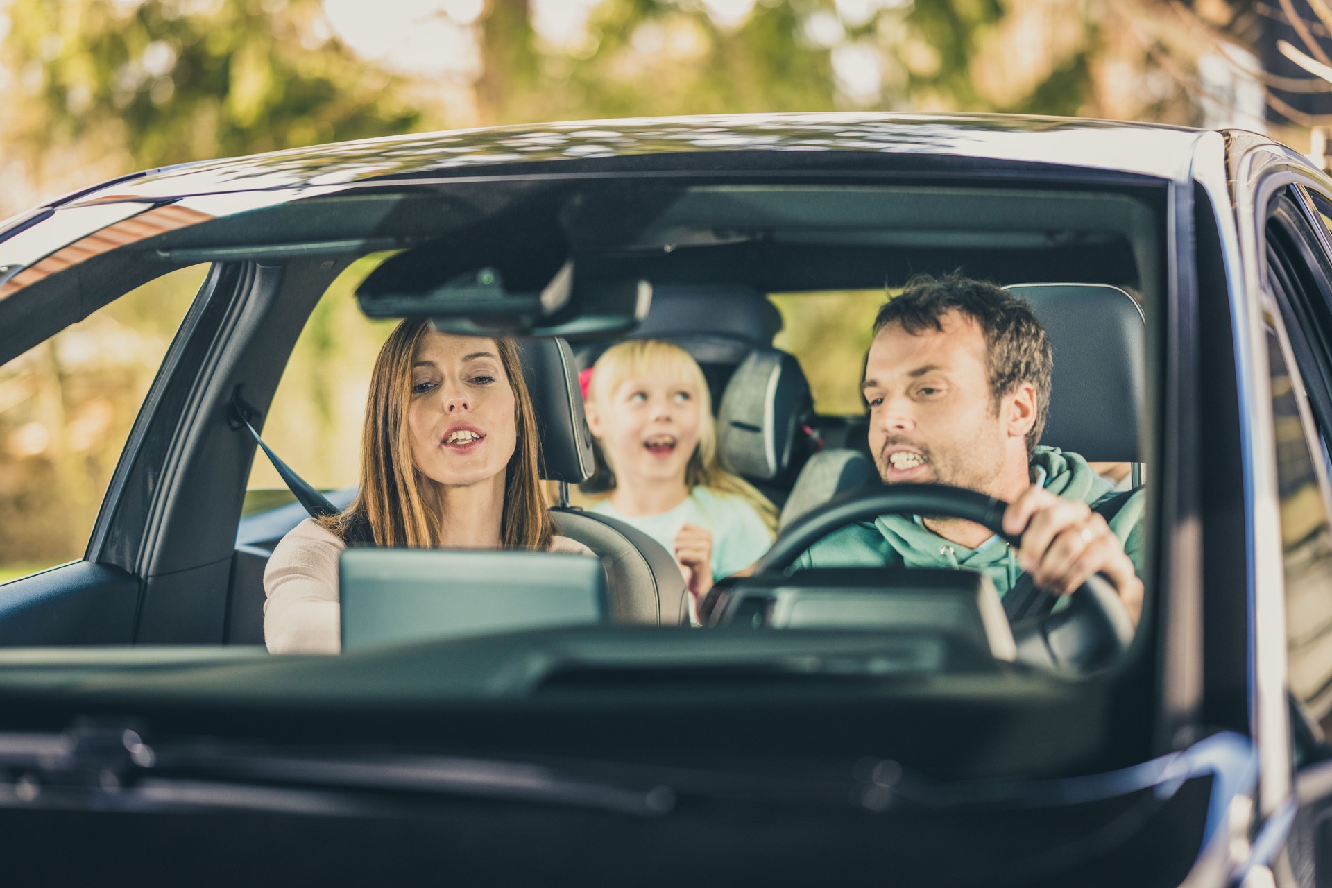 Happy family enjoying in car during road trip