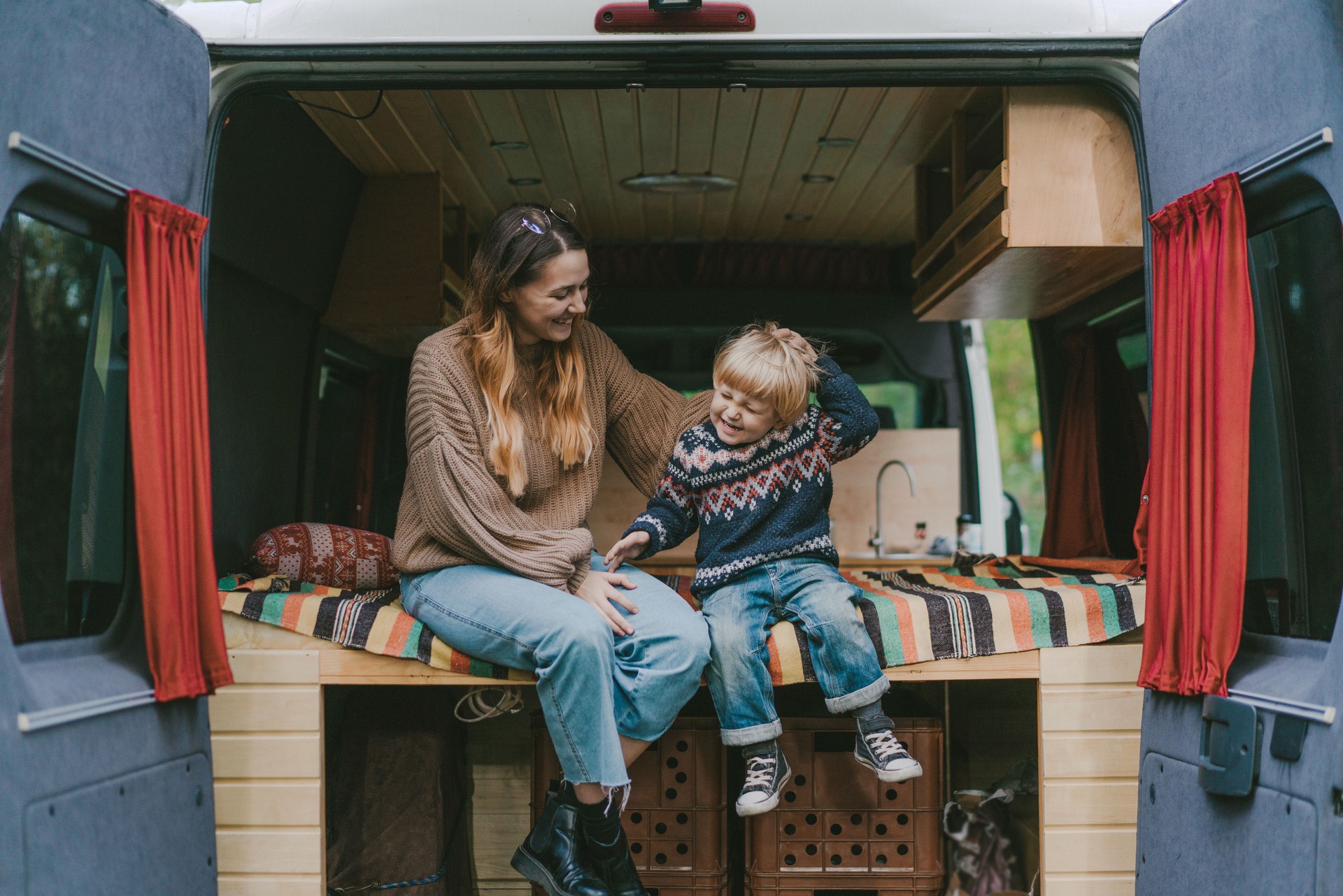 Woman with son sitting in camper van